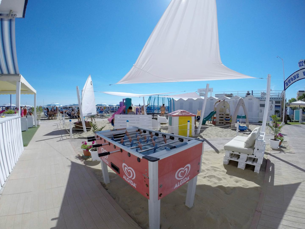 Spiaggia con calcetto, area giochi e ombrelloni, ideale per il relax estivo.